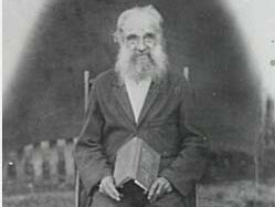 Man sitting in chair with book in his hand