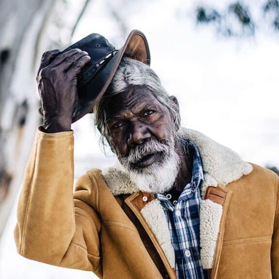 A midshot of David Gulpilil tipping his Akubra hat