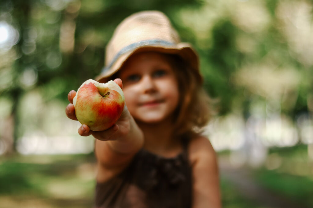 Portrait of a child with an apple in his hands. Baby 5 years old