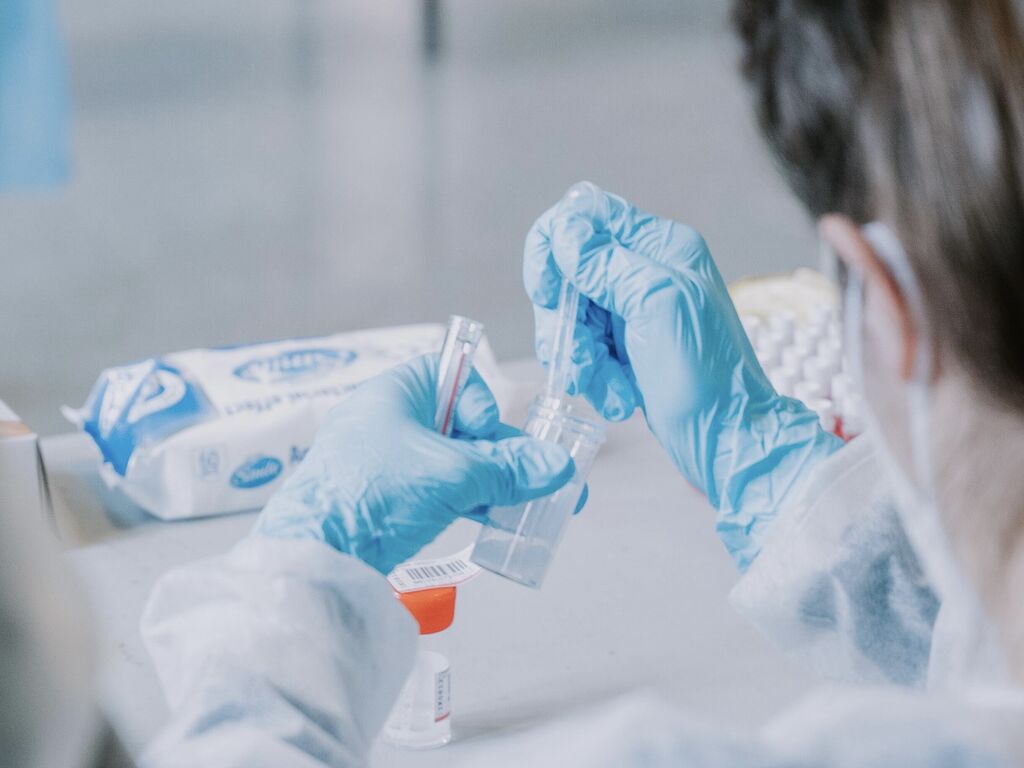 close-up of gloved hands administering a COVID-19 test