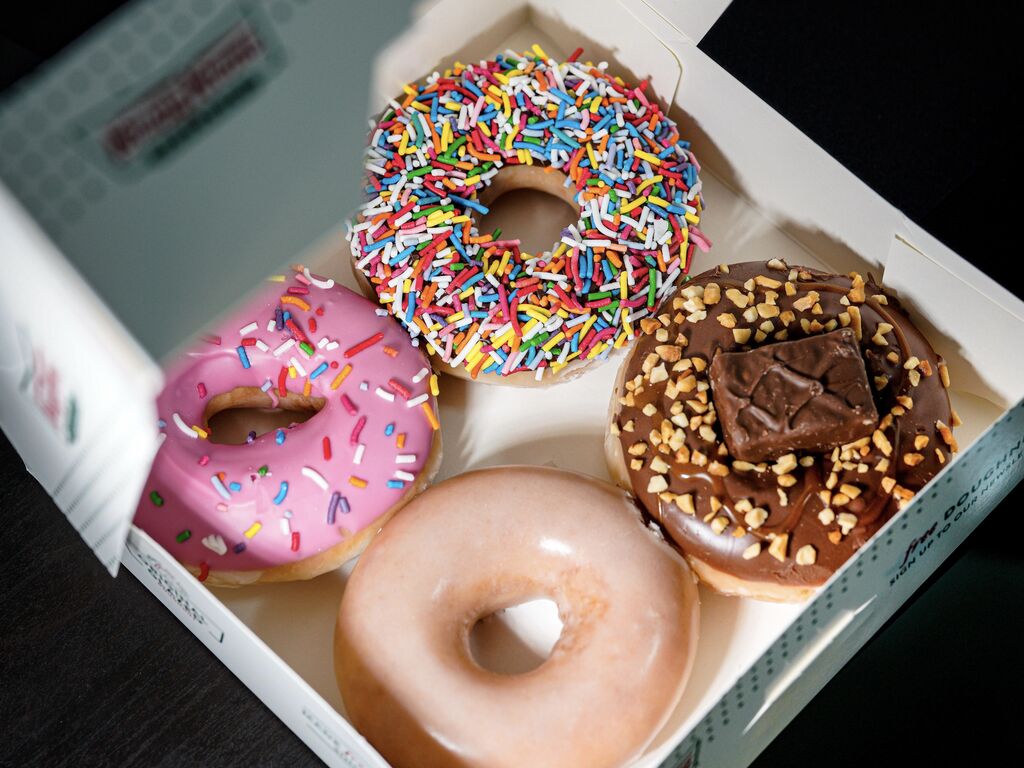 A close-up shot of assorted Krispy Kreme donuts in a box