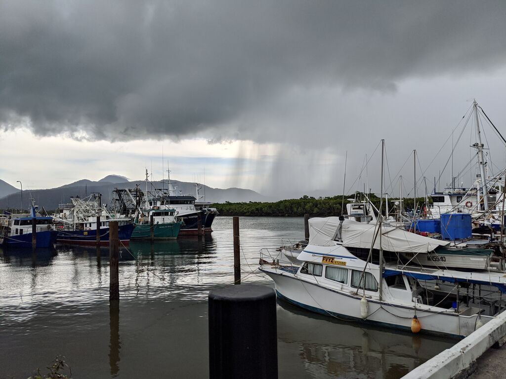 Boats in Trinity Inlet with a very stormy dark sky in the backdrop